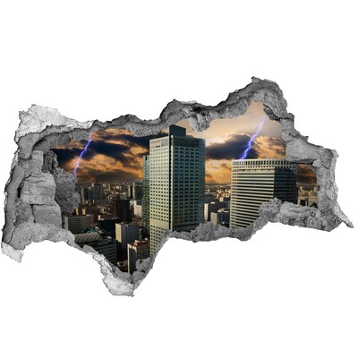 Sticker effetto rottura muro Veduta della città sotto un cielo tempestoso
